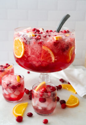Cranberry Grapefruit Punch in punch bowl. with glasses full of punch.