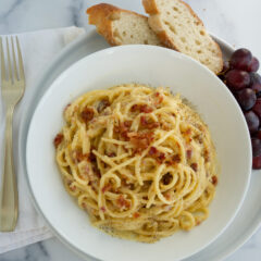 Spaghetti Carbonara with Bacon on a white bowl served with bread