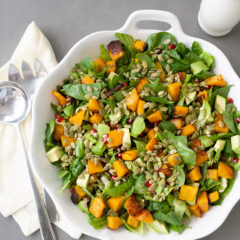 Harvest Salad with Buttermilk Sage Dressing in white serving platter with serving utensils