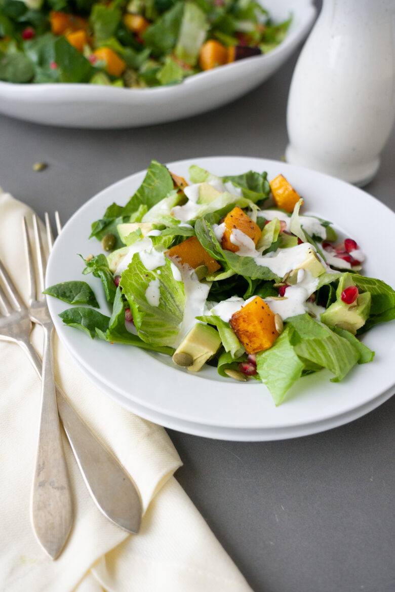 Harvest Salad with Buttermilk Sage Dressing on white plate with dressing