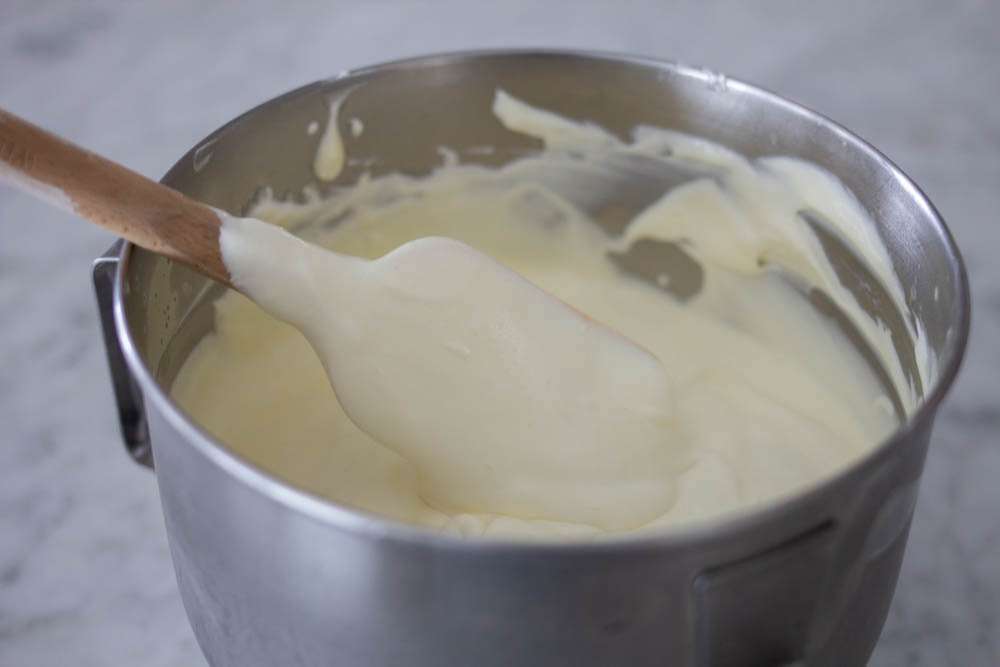 Mixing bowl with spatula and  whipping cream and vanilla pudding