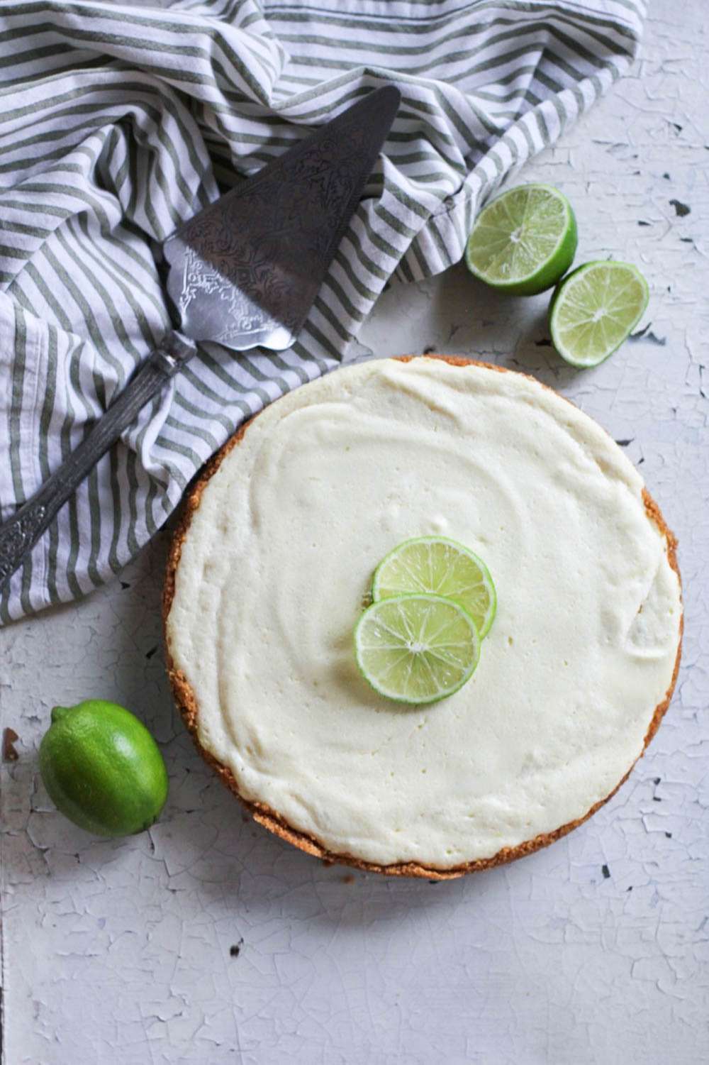 Key Lime Pie with limes and serving utensil