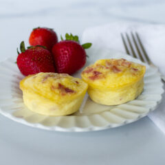 Gruyère and Bacon Egg Bites on white plate with strawberries