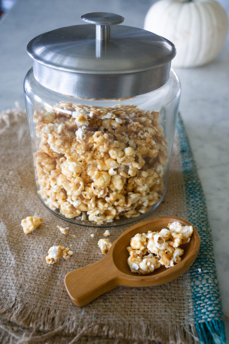 The Very Best Crunchy Caramel Corn in glass container with scoop