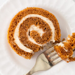 Pumpkin roll with fork and white plate.