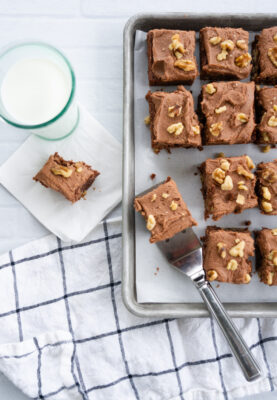 Carole Merrell"s Famous Frosted Brownies, tray of brownies and a glass of milk with brownie.