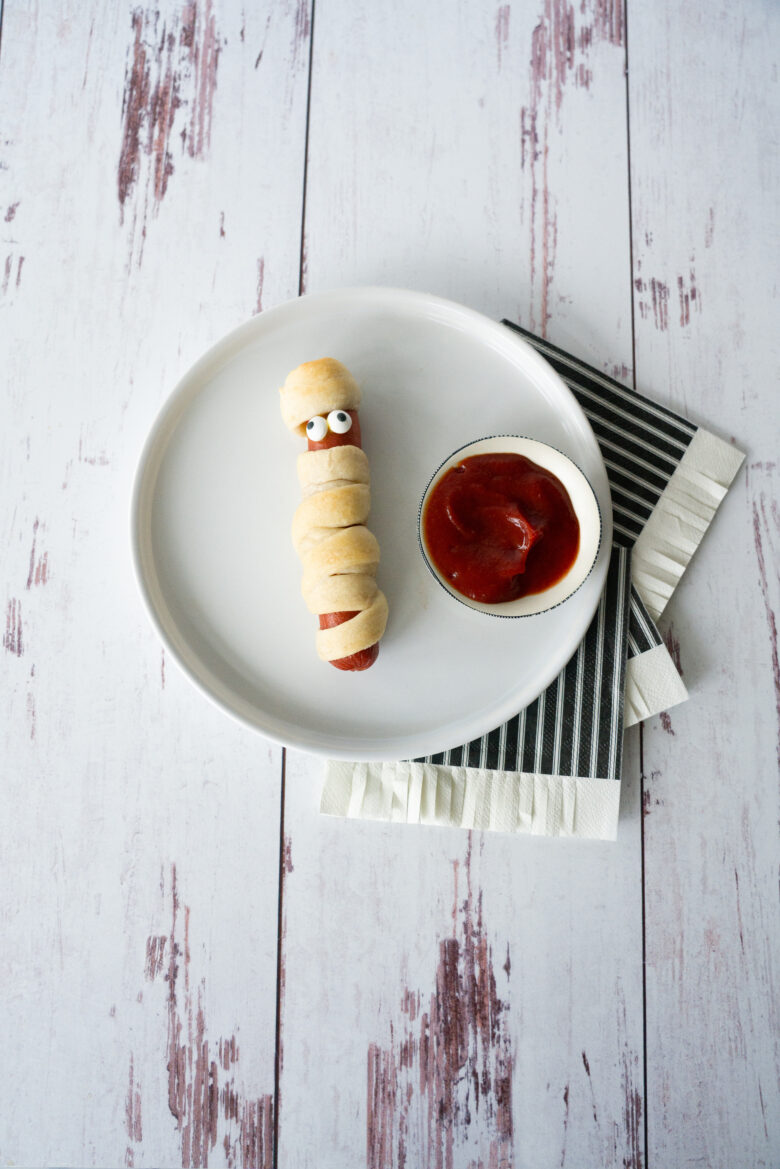 Mummy Hot Dog on a plate with dip