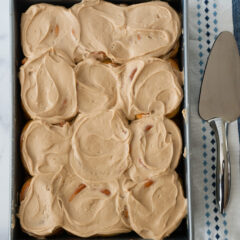 9x13 pan of Maple Cinnamon Rolls with serving utensil beside.