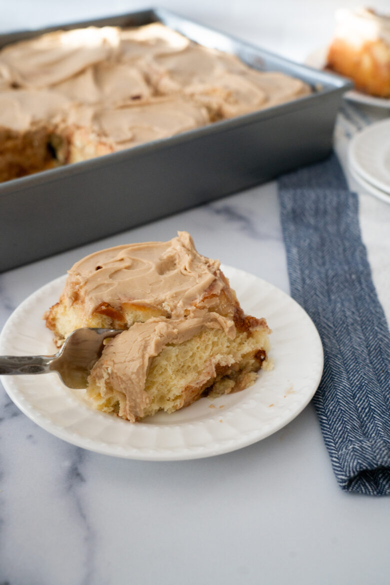 fork cutting into a maple cinnamon roll