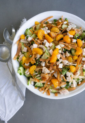 White serving bowl and serving spoons with Asian Wonton Chicken Salad